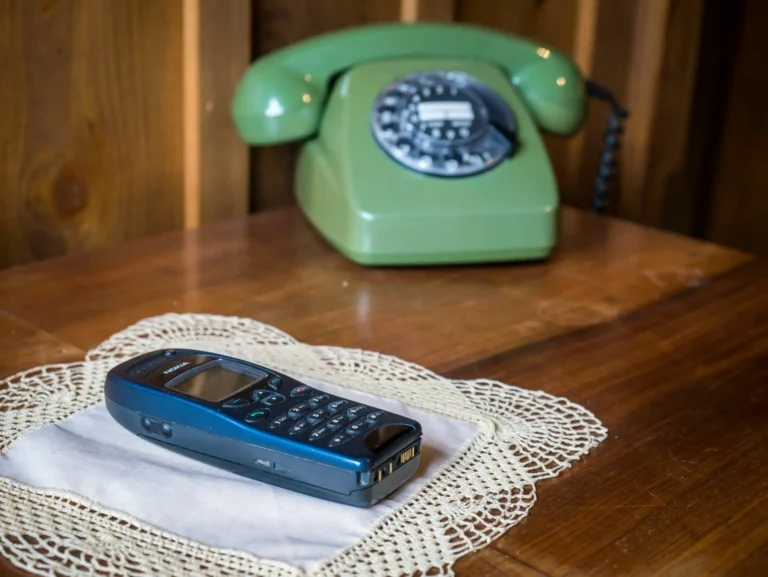 deux anciens téléphones posés sur une petite table en bois
