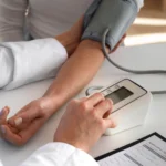 un docteur prend la tension de son patient avec un tensiomètre automatique