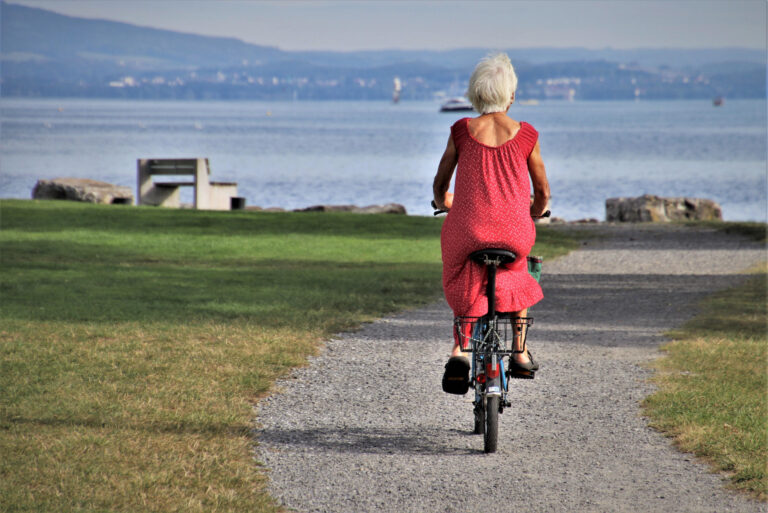 Une femme âgée sur son vélo se dirige vers un lac